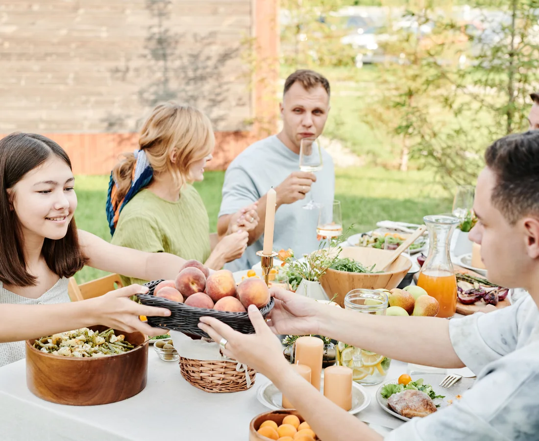 Familie teilt an einem hellen Sommertag gemeinsam ein Mittagessen im Garten