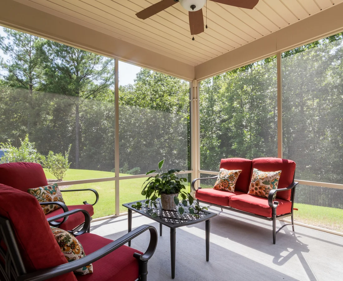 Helle überdachte Wohnterrasse mit Sitzbereich und weitem Blick in einen Garten